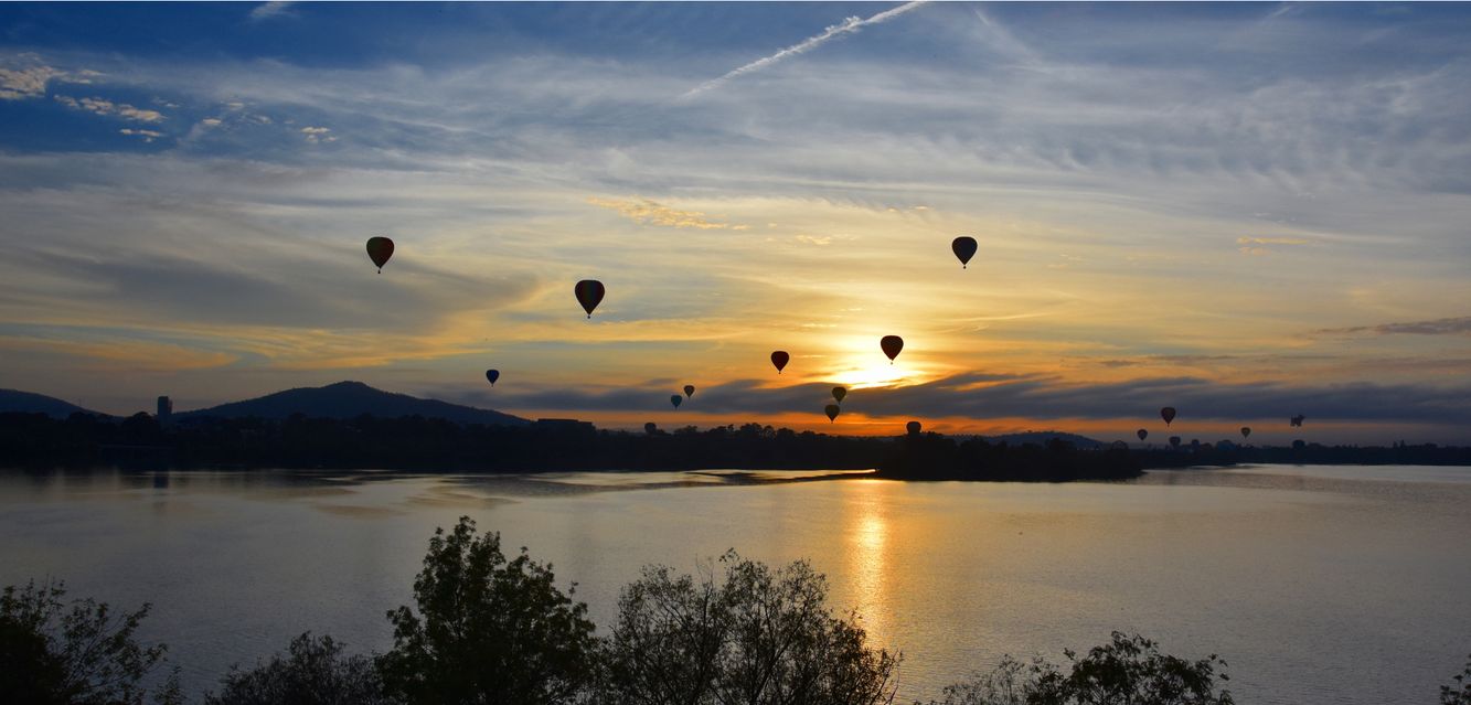 Hot air baloons flying above Lake Burley Griffin. 