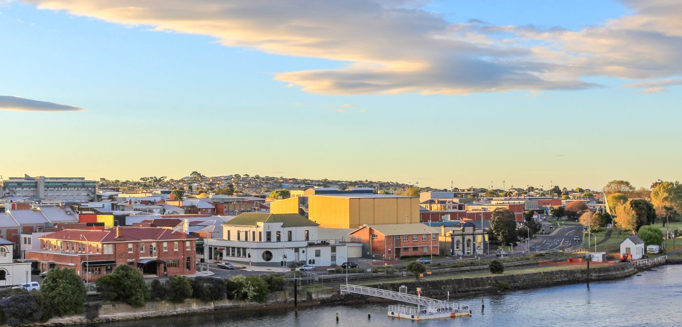The sun sets over Devonport and the Mersey River.