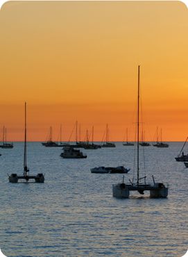 Catamarans in a bay at sunset over sea. Darwin, Australia.