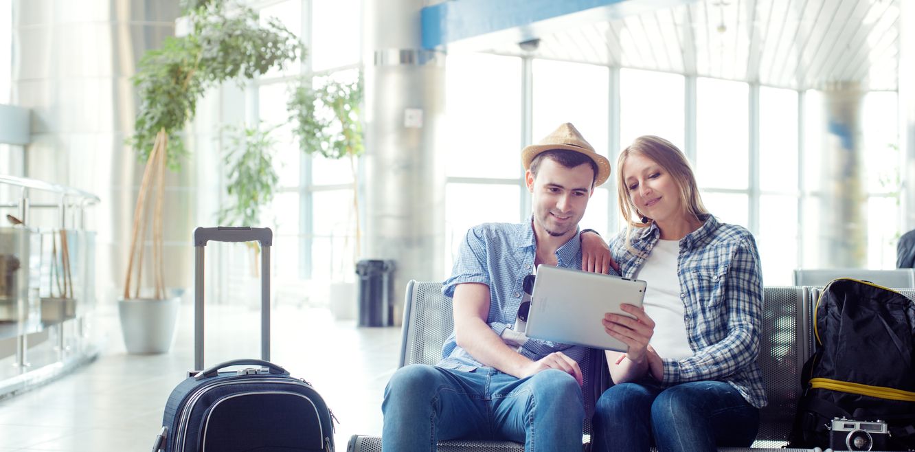 Couple booking a hire car in an airport lounge