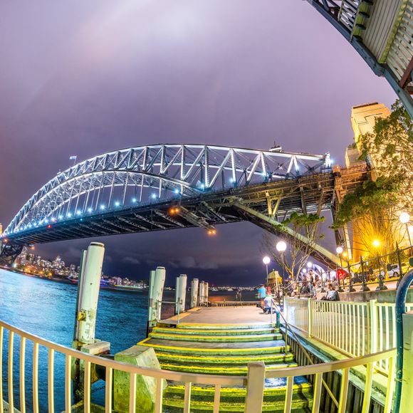 Beautiful view of Sydney Harbour Bridge with a sunset sky.