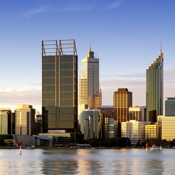 Perth at dusk with the Swan River in the foreground.
