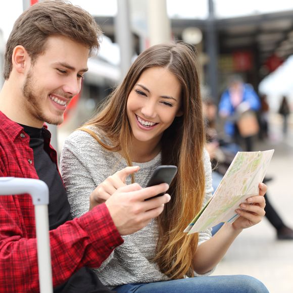 Travellers check their mobile phone.